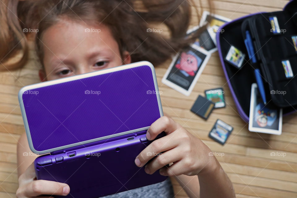 Girl playing Video Games on her Nintendo DS