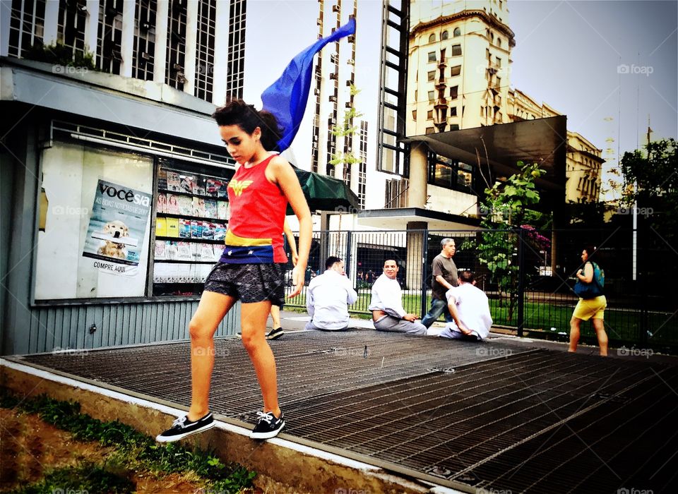 Girl wearing superwoman outfit with a flying cape