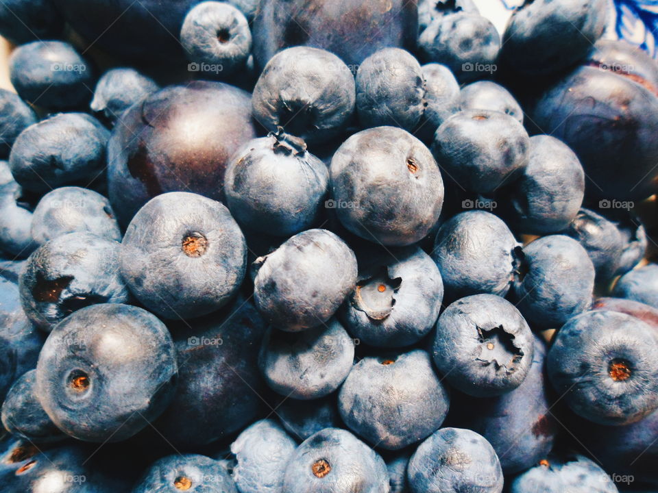 Berries of blueberries and plums on a white plate