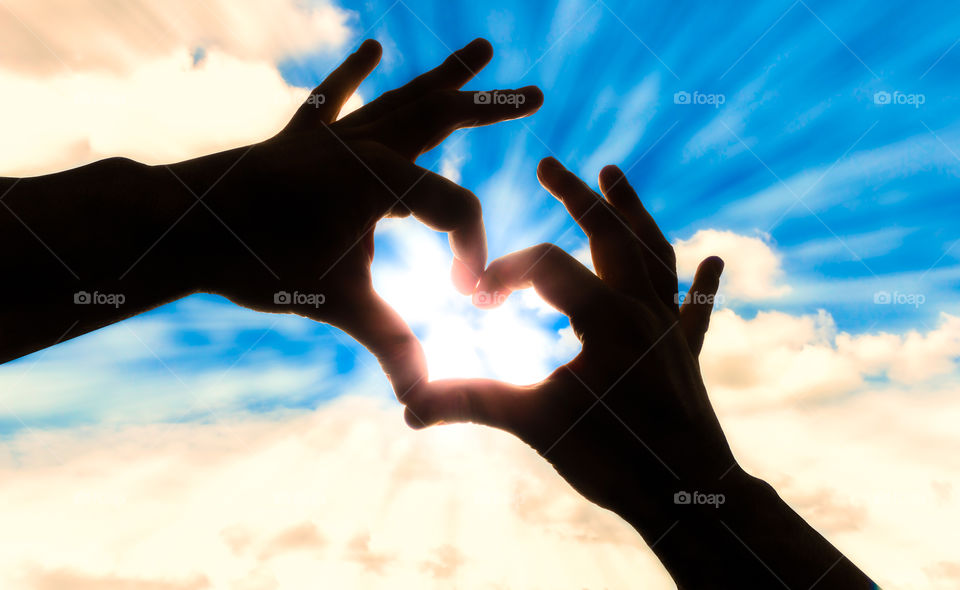 Silhouette hands in heart shape and blue sky. Silhouette hands in heart shape and blue sky