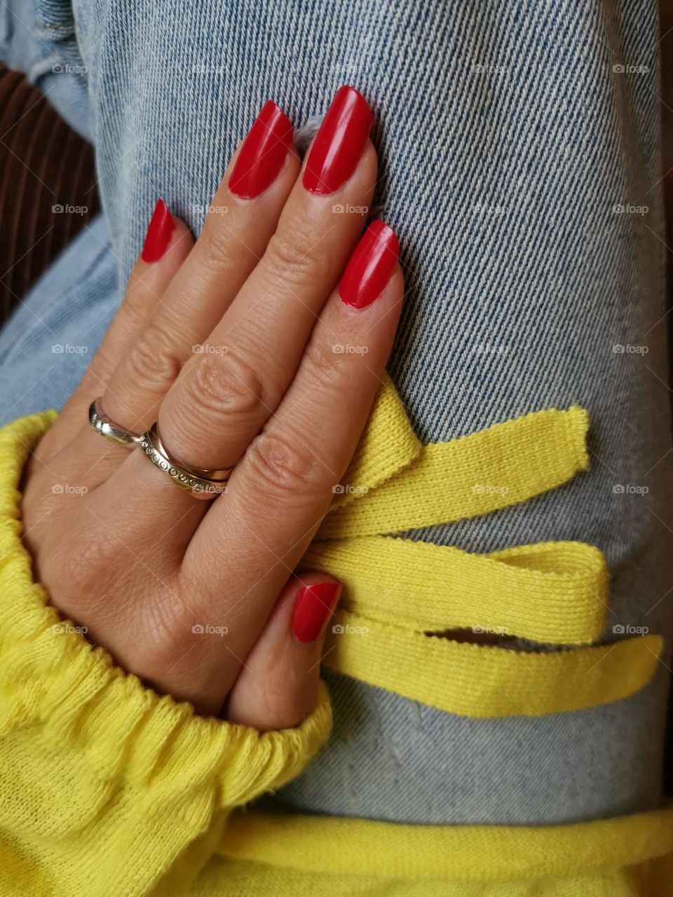 Red manicure, red nail polish . Yellow jumper.