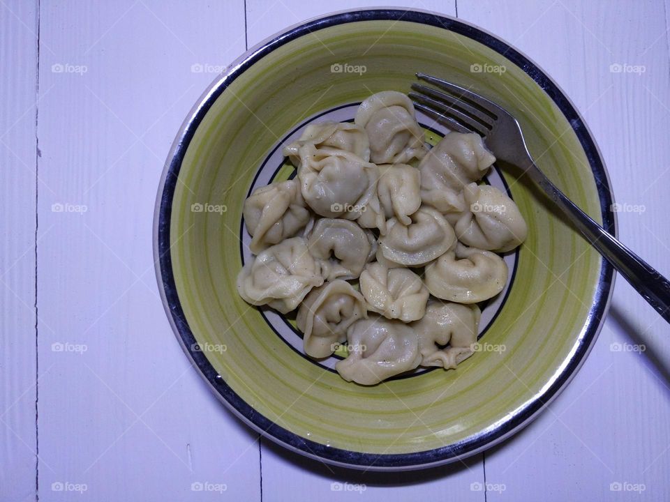 a plate of homemade dumplings on a white background