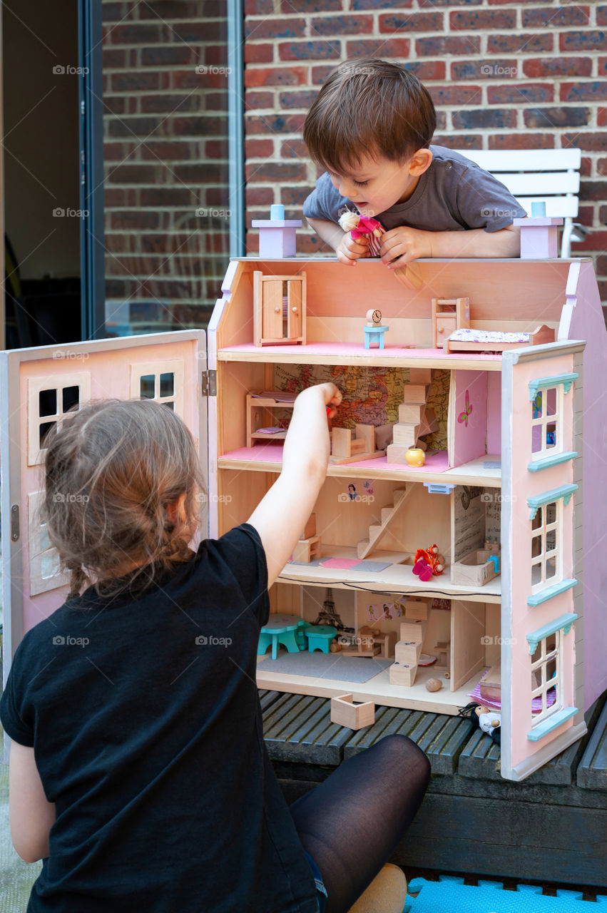 Children playing with doll house.