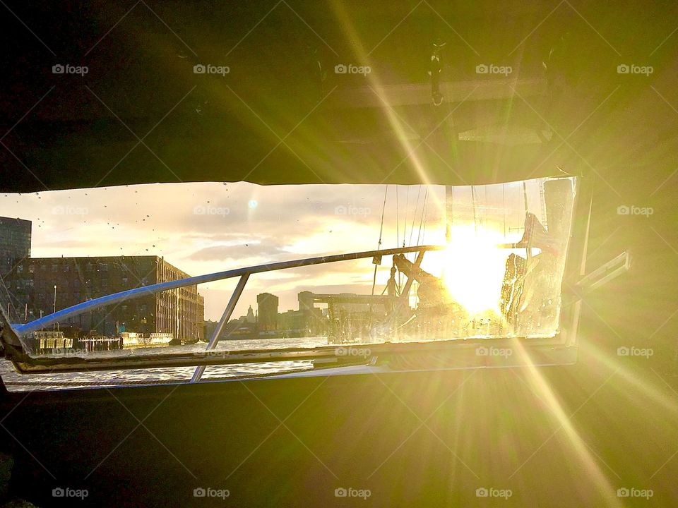 A view out onto Newtown Creek in Long Island City, Queens, NY from aboard the “Salvation” during the golden hour of sunset and upcoming nightfall with a dramatic lens flare caused by the incredibly powerful rays of our sun. 2021. Hypnotic Productions