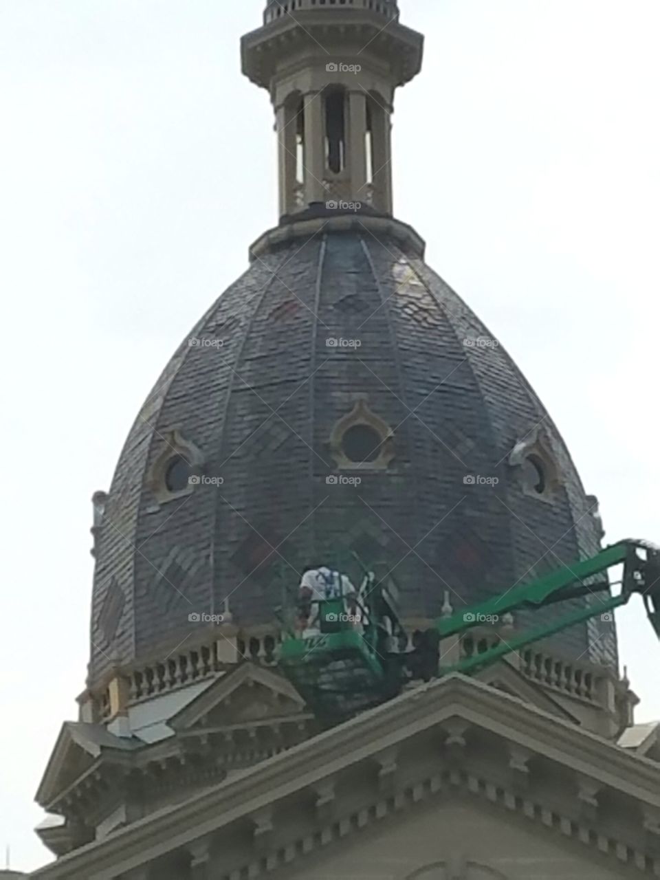 Dome cupola on Town Hall renovation in progress. Manlift machinery, workers working.