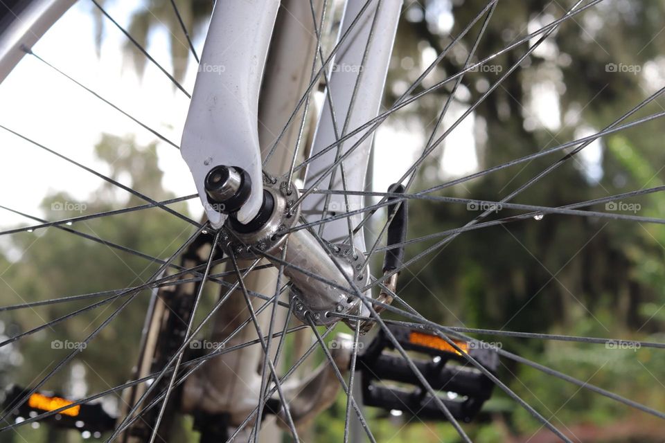 Closeup Bicycle front wheel rim with raindrops on spokes bokeh background 