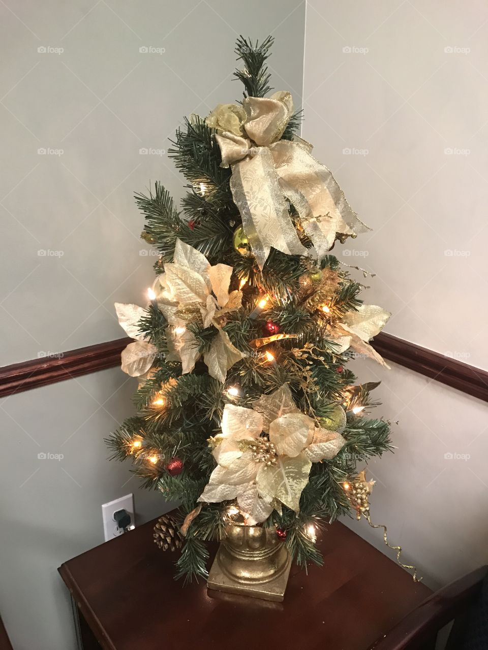 Small Christmas tree with gold poinsettia and gold ribbon 