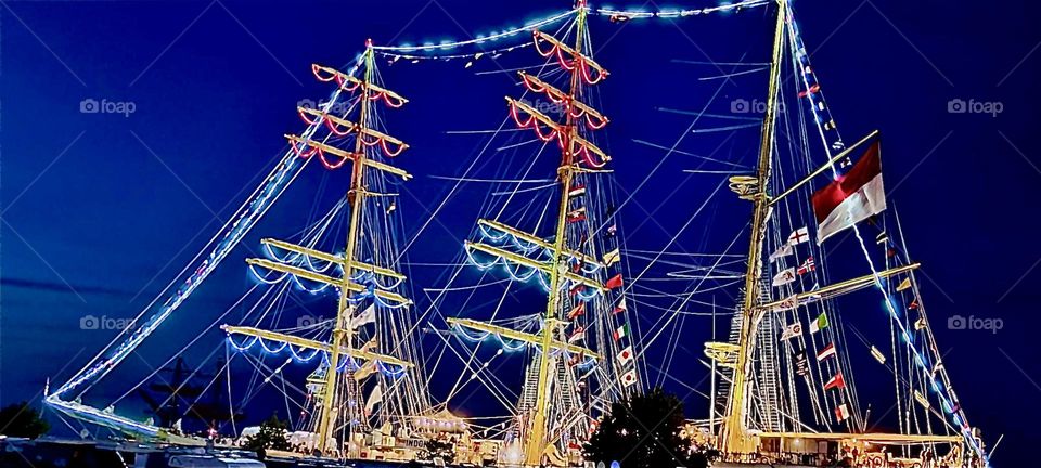 The “Hanse Sail” in “Rostock”, Germany is an annual regatta when all kinds of sailboats are shown to the public. Some are old or old style models, tours are offered and special attractions such as this boat lit up at night. 2023. Hypnotic Productions