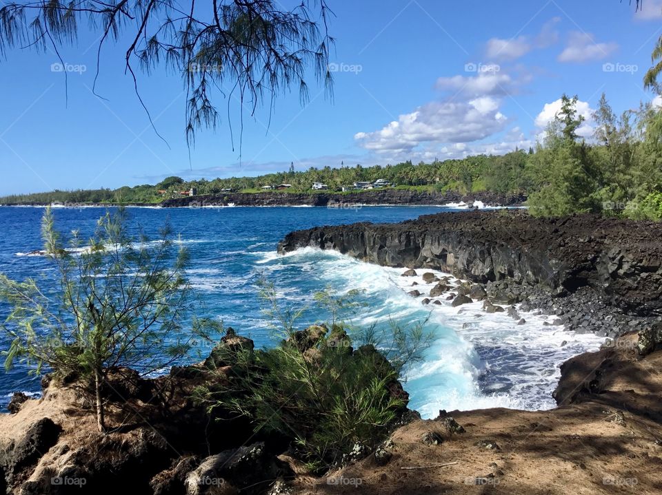 Wave hitting a black sand beach