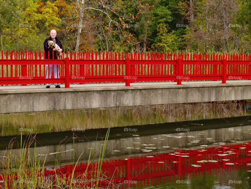 A man and his dog. A man and his dog on a red bridge