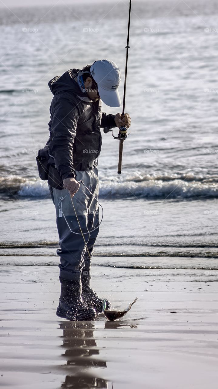 fisherman on the beach catches a fish