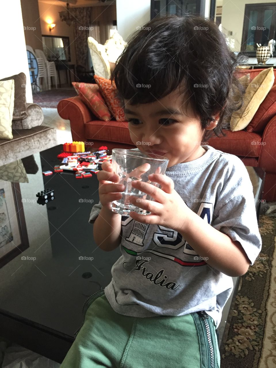 Candid picture of a little boy drinking water.