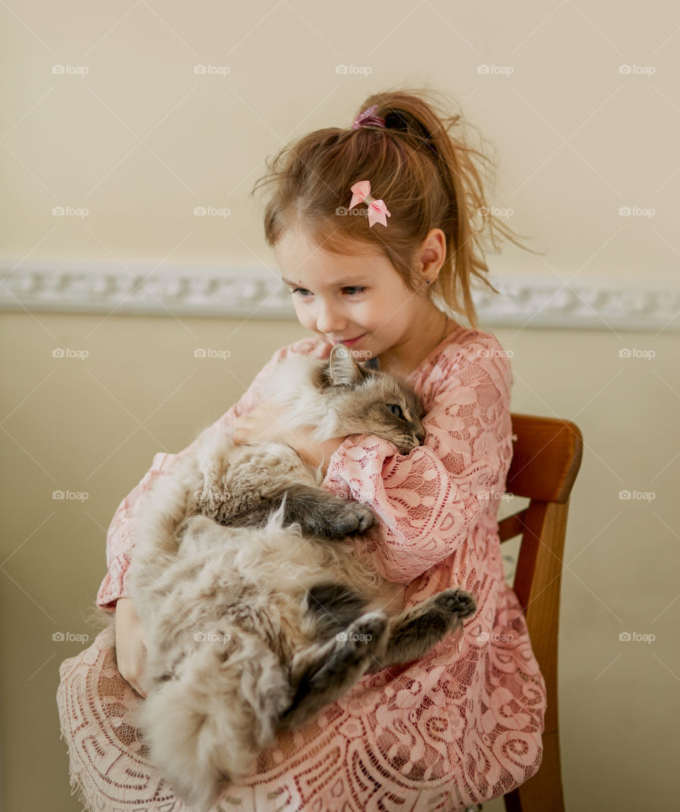 Vintage portrait of a beautiful little girl with rag-doll cat