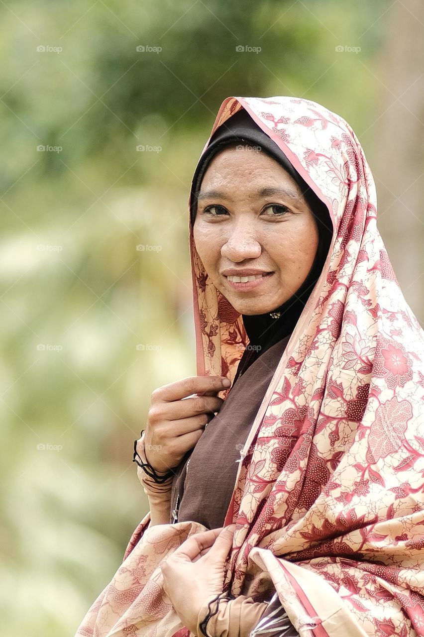 Malay woman wearing traditional attire with hijab.