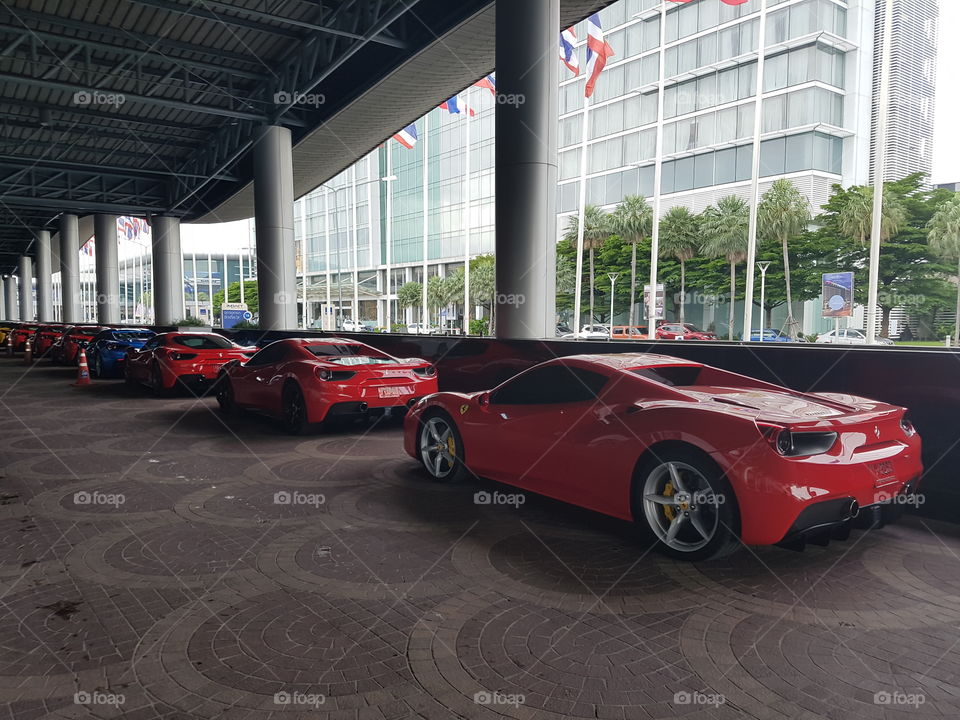 Red Ferrari 488 spider twin-turbocharged V8 luxury sports car parked in line