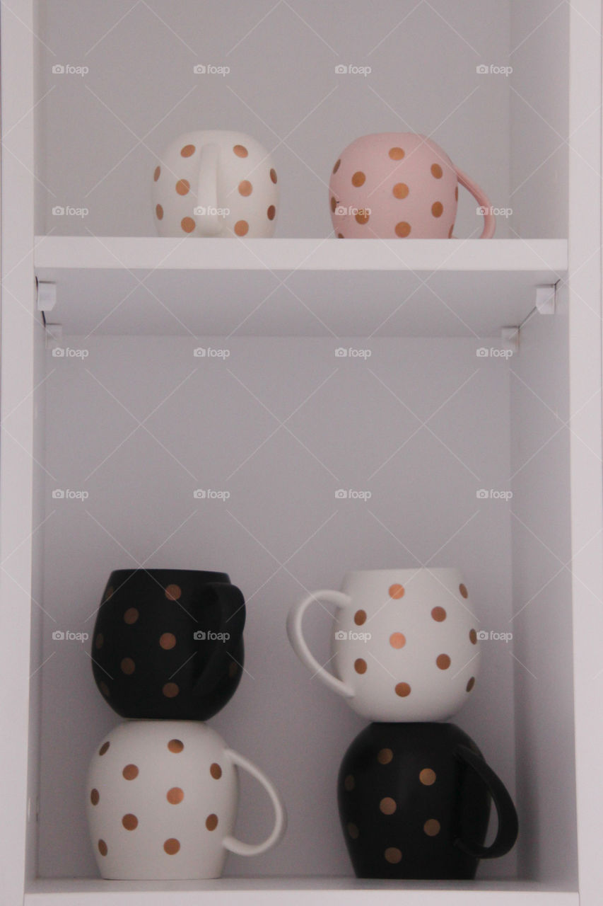 hug mugs sitting stacked on the kitchen shelf