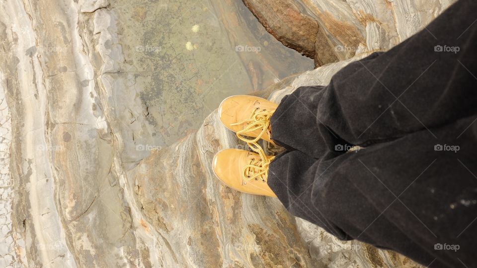 In yellow boots, in search of tide pools and rock stratification on the coast if Carmel, California
