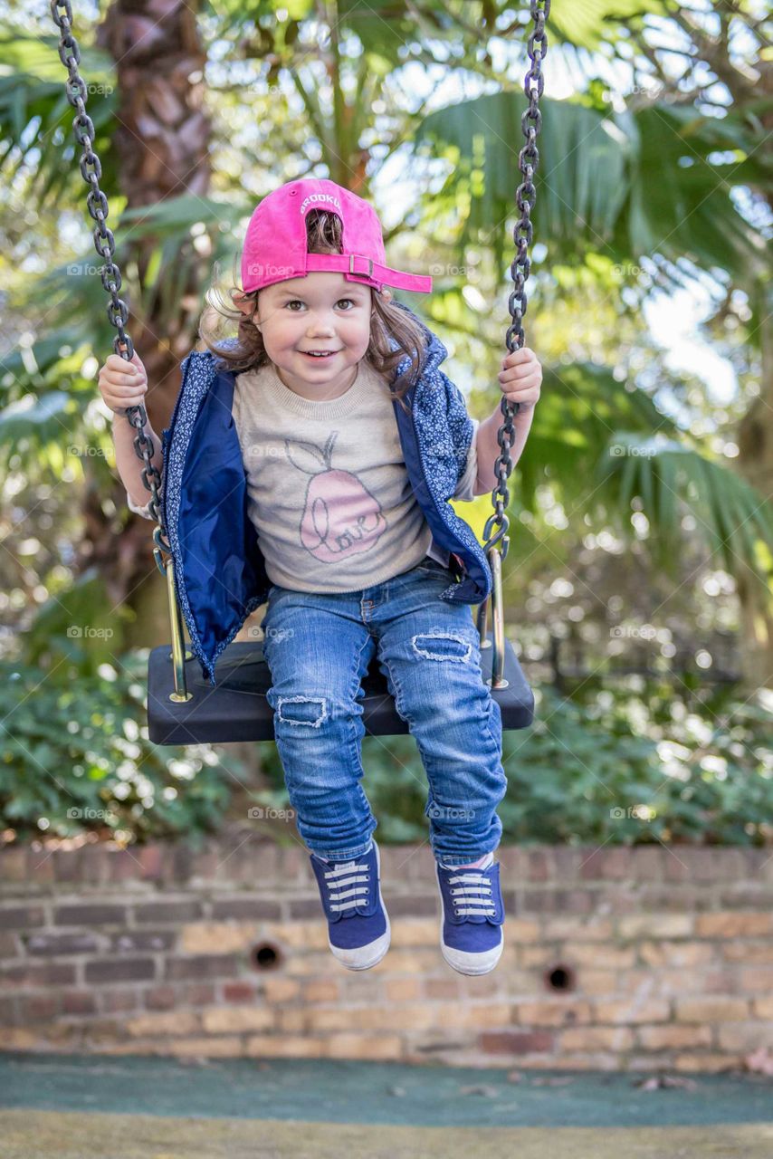 Small girl playing on swing