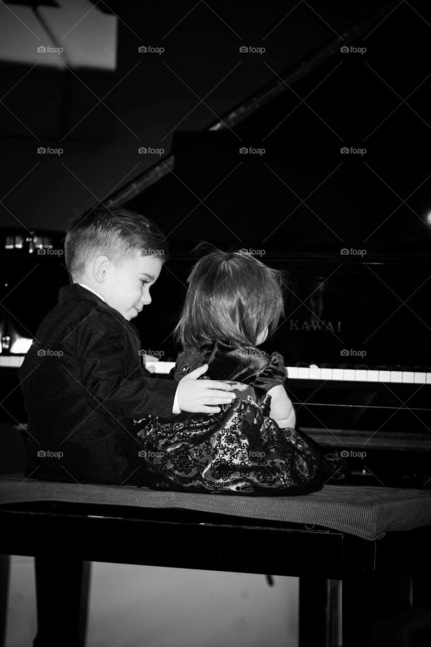Little siblings playing piano
