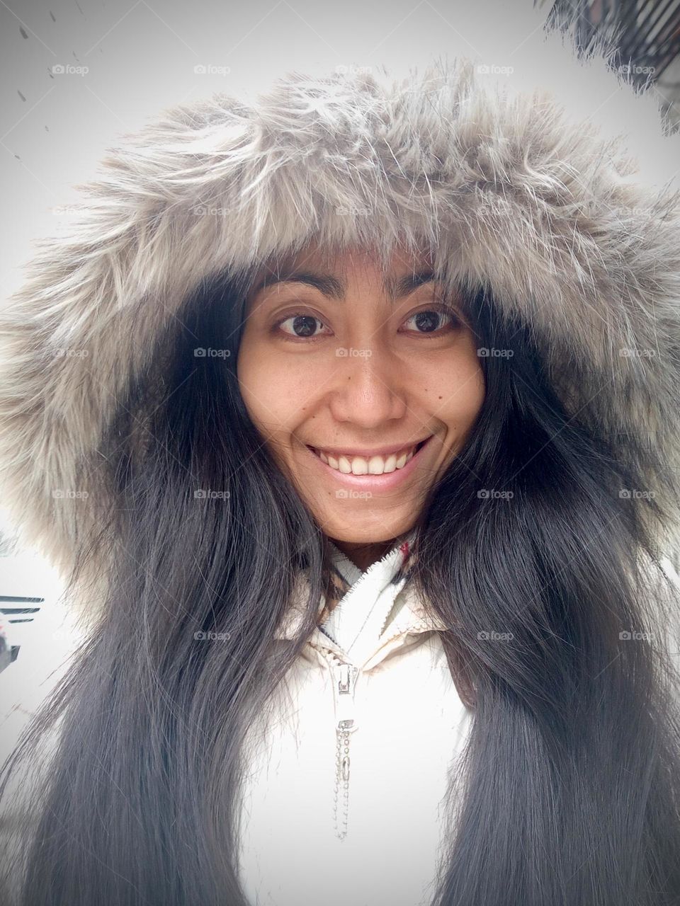 A woman’s with long hair wearing a white coat.
