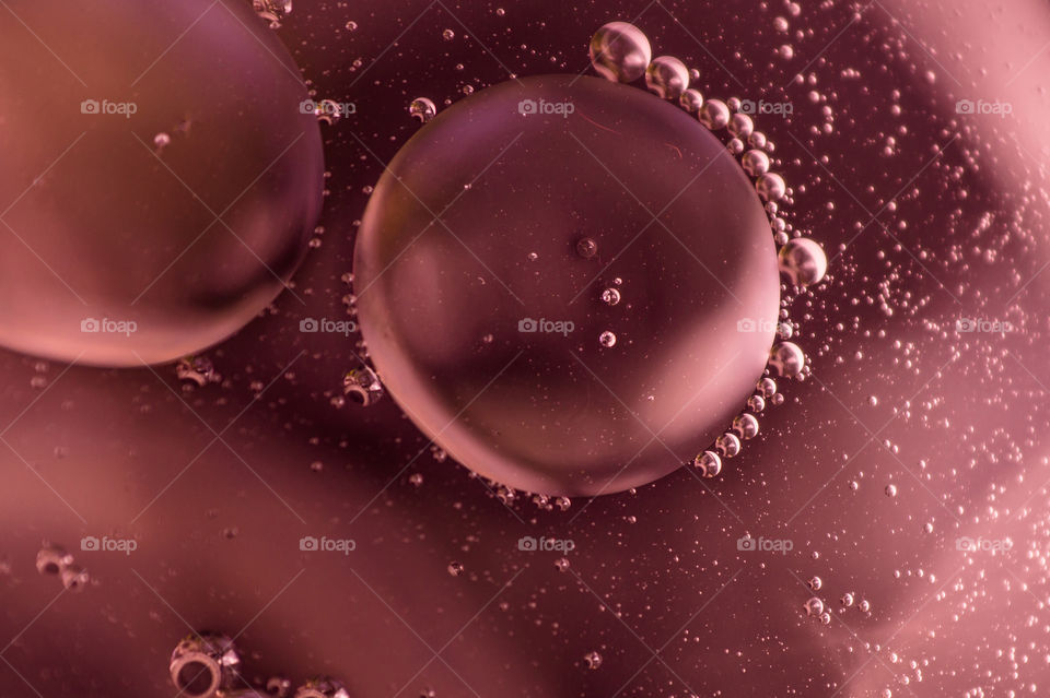 Small bubbles of vegetable oil in water close-up.