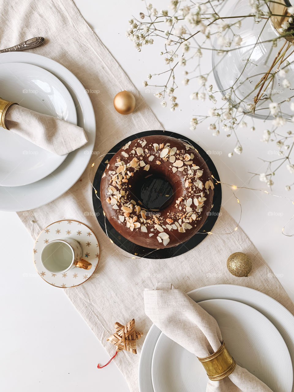 Round chocolate cake on white festive table, top view 