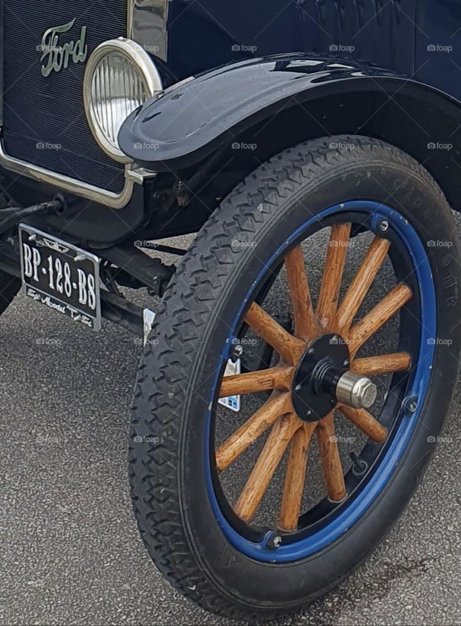Part of a navy blue Ford T car front with a front light and close-up on one of the tyre at Cherbourg's car show