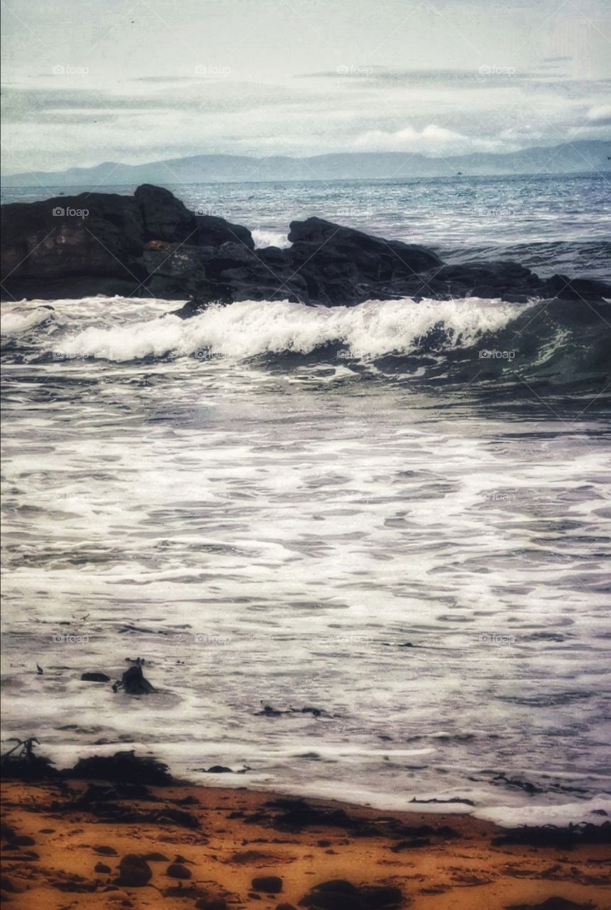 Waves over rocks on a beach