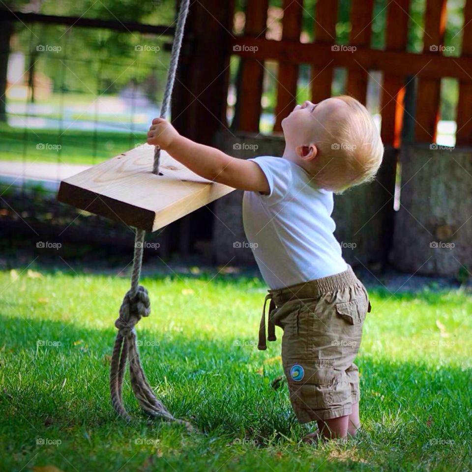 Big Swing, Little Boy. Baby boy looking up the rope swing. 