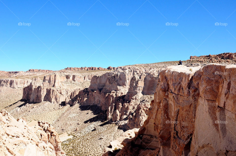 Man sitting on the top of a cliff