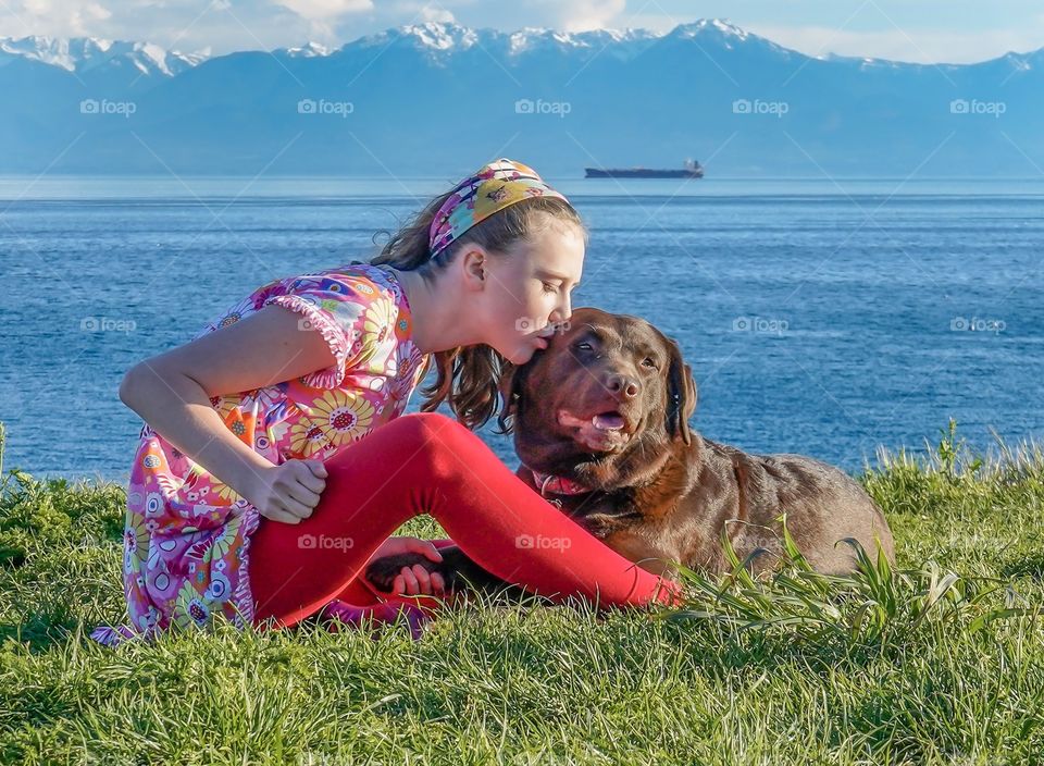 Girl kissing Labrador retriever 