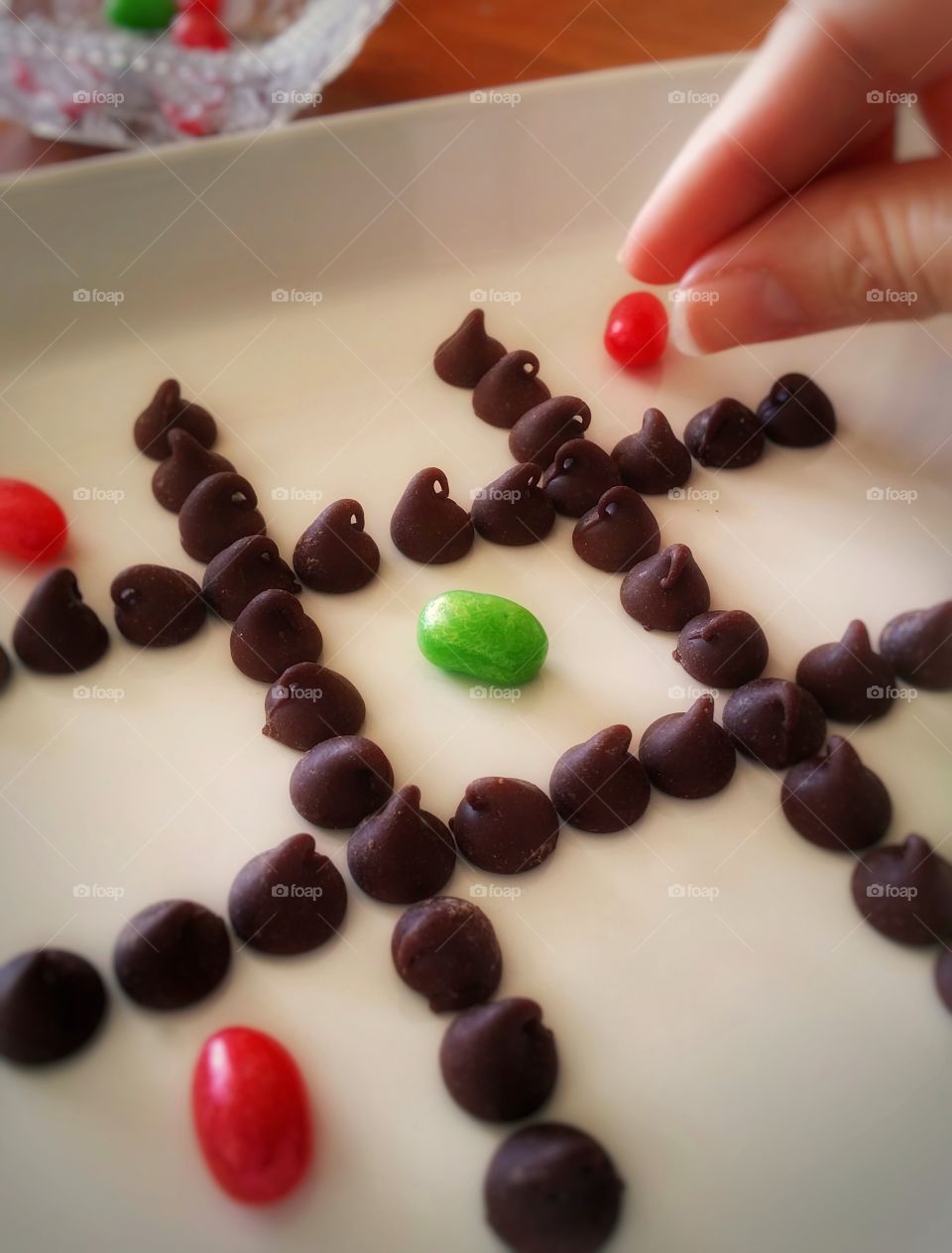 Playing tic-tac-toe with green and red jellybeans and chocolate chips