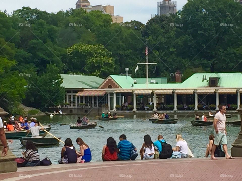 Group of tourists on boat at lake near house