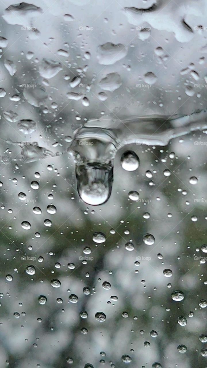 rain drops on the windshield with reflection  of the trees in them in macro