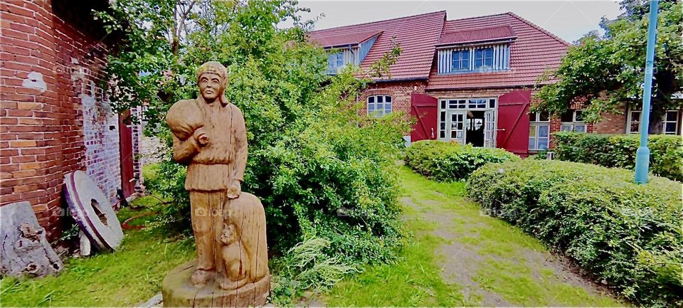 A wooden sculpture greets guests of the restaurant in the old mill in “Rostock” by the “Baltic Sea”. During the “Hanse Sail”, a big regatta held every year in August business should definitely be more than usual. 2023. Hypnotic Productions