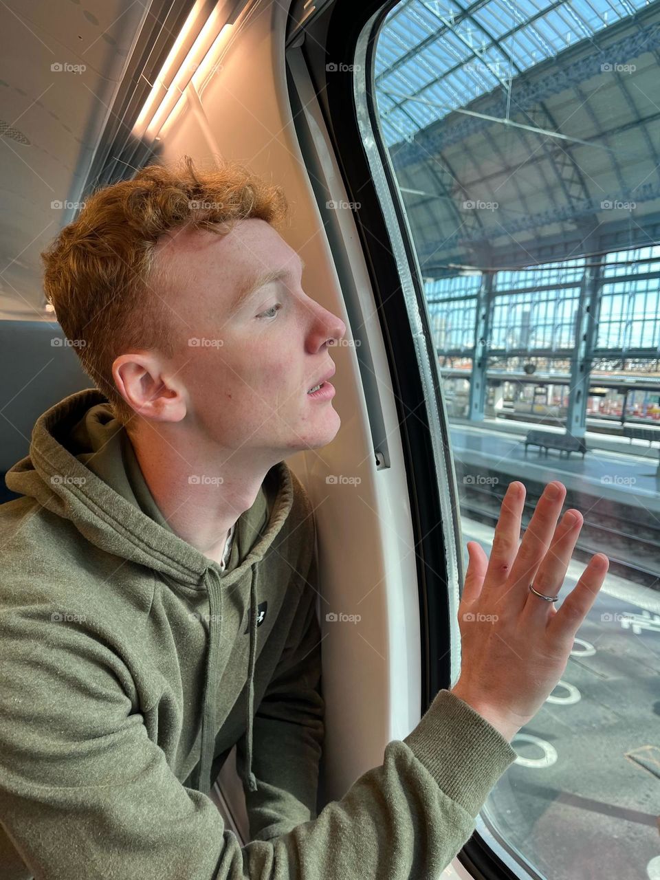Anxious young man looking out the window of a train