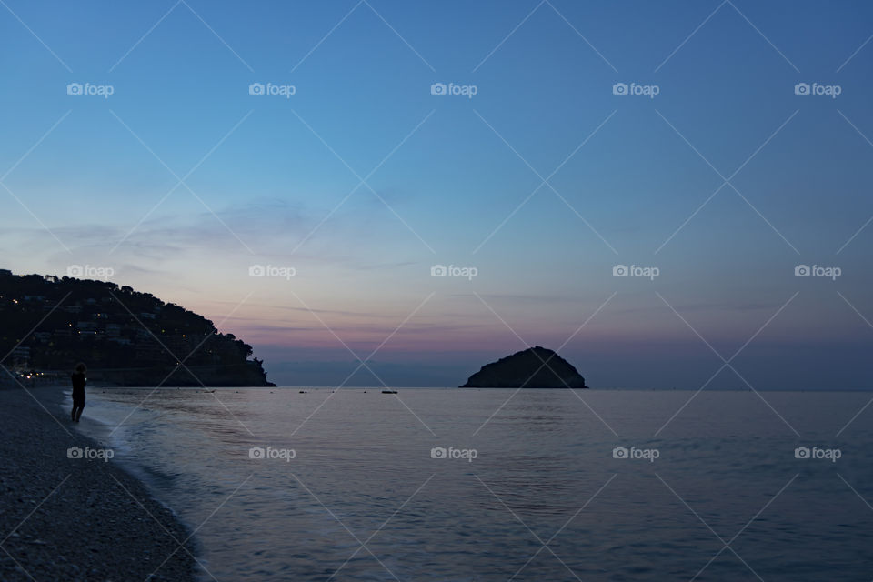 Sunrise over the sea. The sun rises from behind the peninsula and passes from the islet next to it.
Wonderful colors are created, including purple, red, orange, blue.