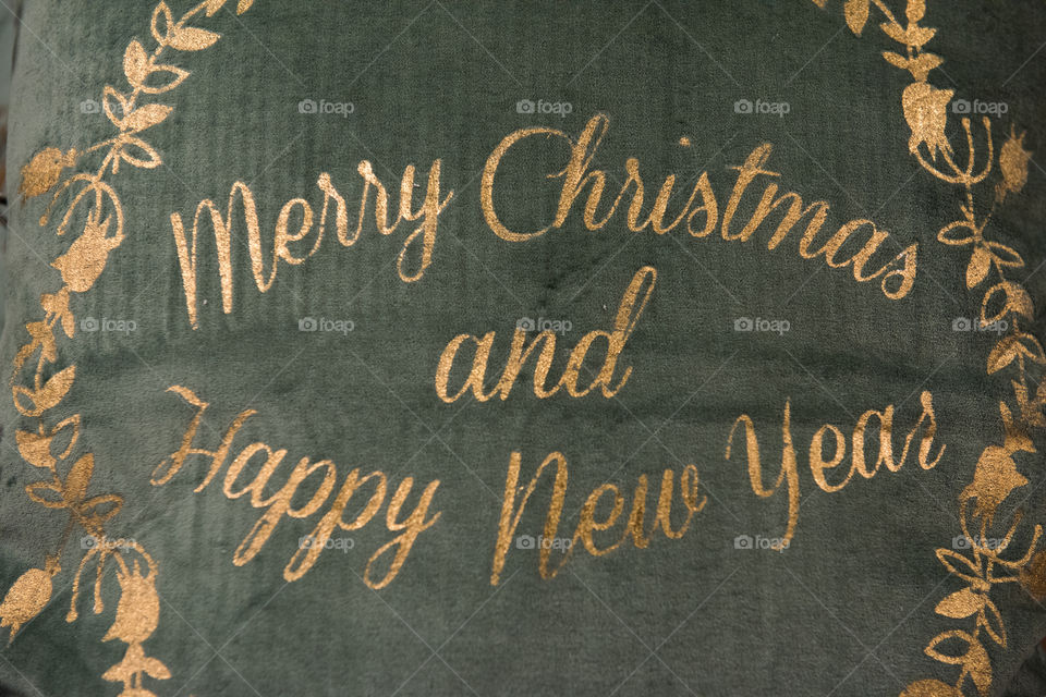 Merry Christmas and a Happy New Year sign on a exclusive pillow.