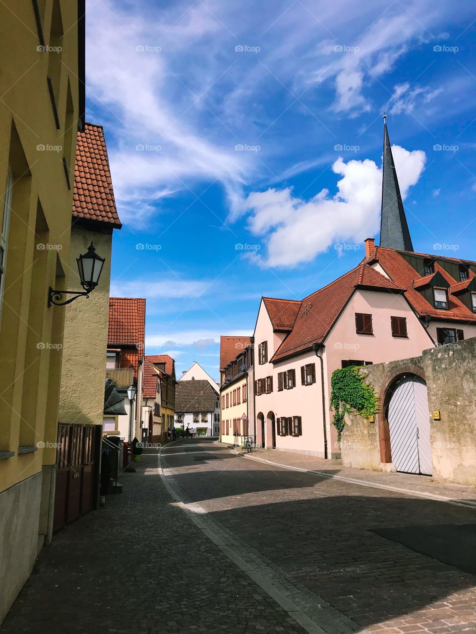 The houses with brown tiled roofs look beautiful amidst the blue sky and white clouds
