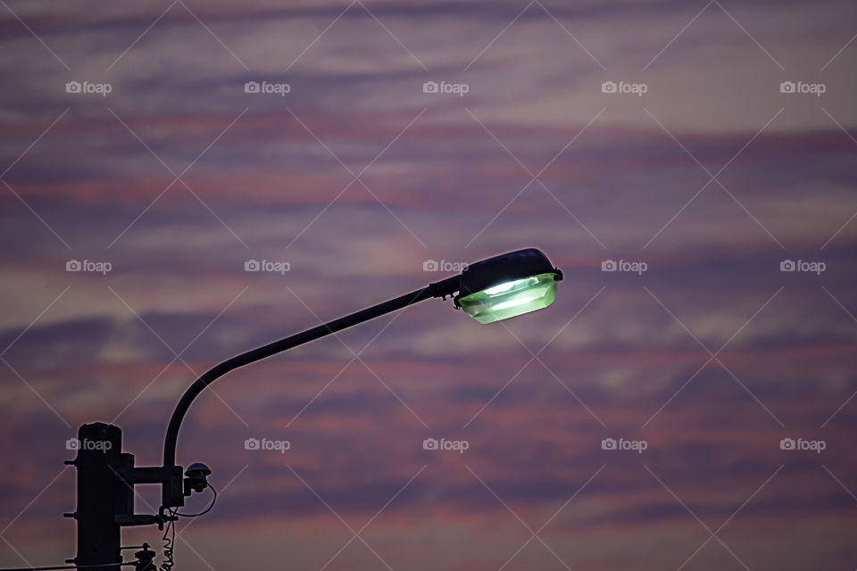 Street lighting and background sunset light reflected with the cloud.