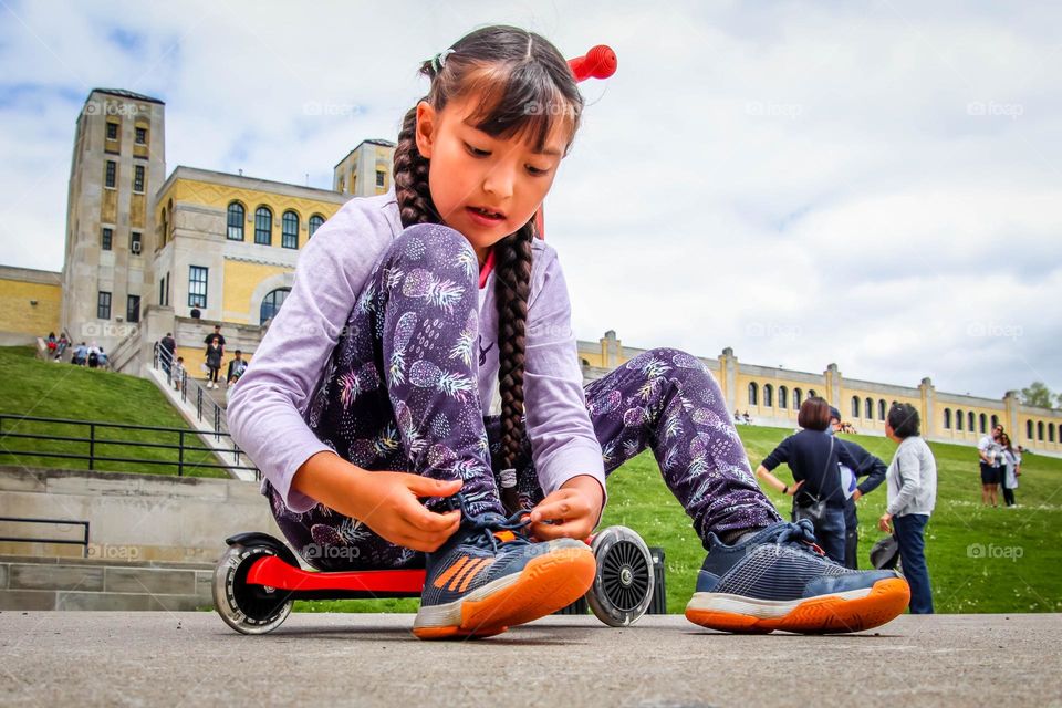 Girl is working on her shoe laces