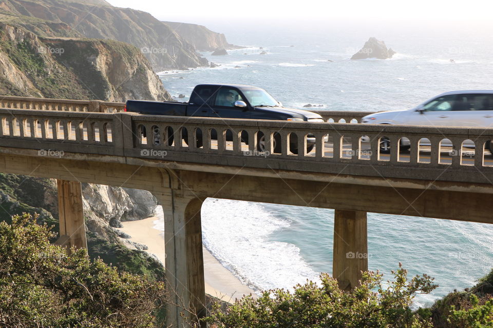 Track driving on the bridge and waves crashing under it