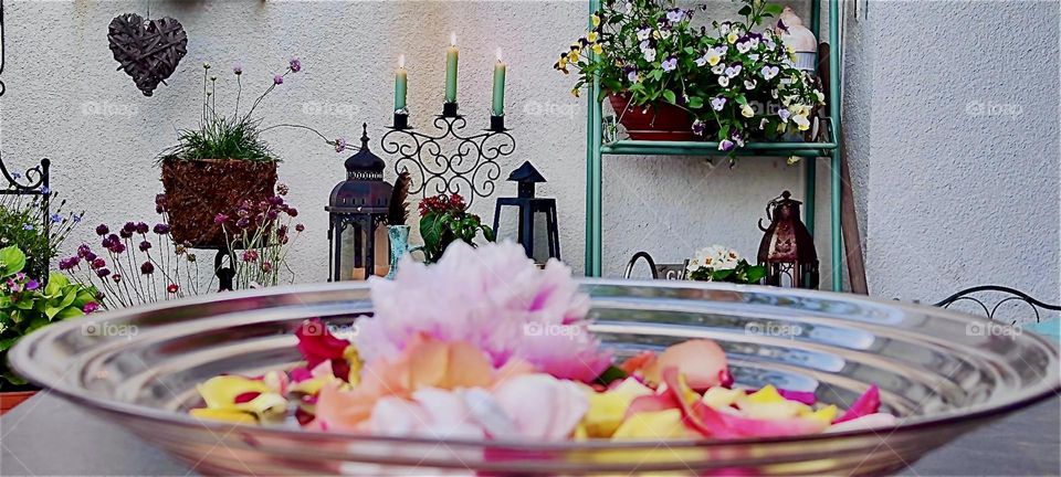 Flower petals can be a sign of devotion as they guide the mind to meditation on a specific topic, remembrance of loved ones who have passed. White candles are burning as well on this terrace in “Lower Bavaria”, Germany. 2024. Hypnotic Productions