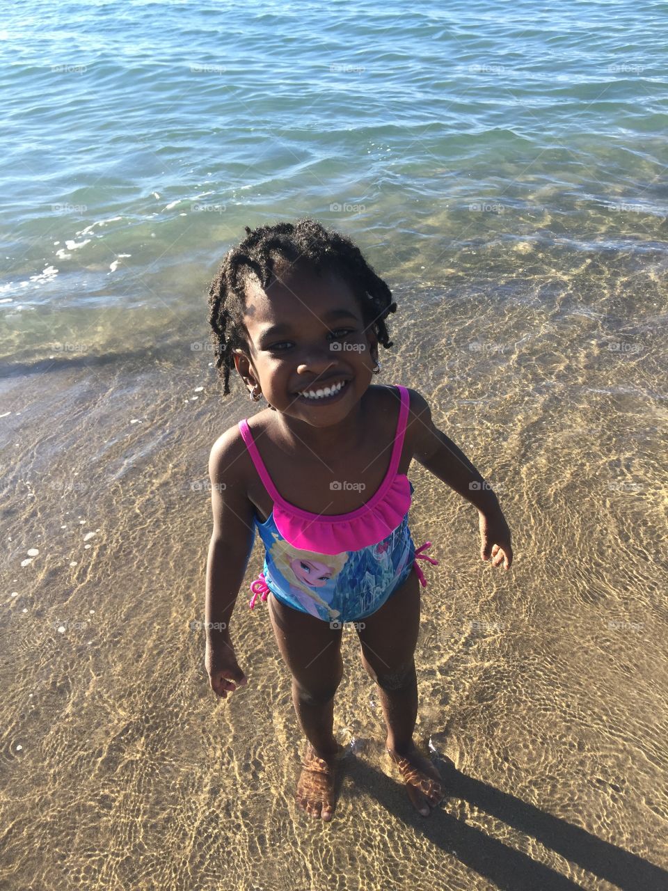 Happy African girl standing on beach