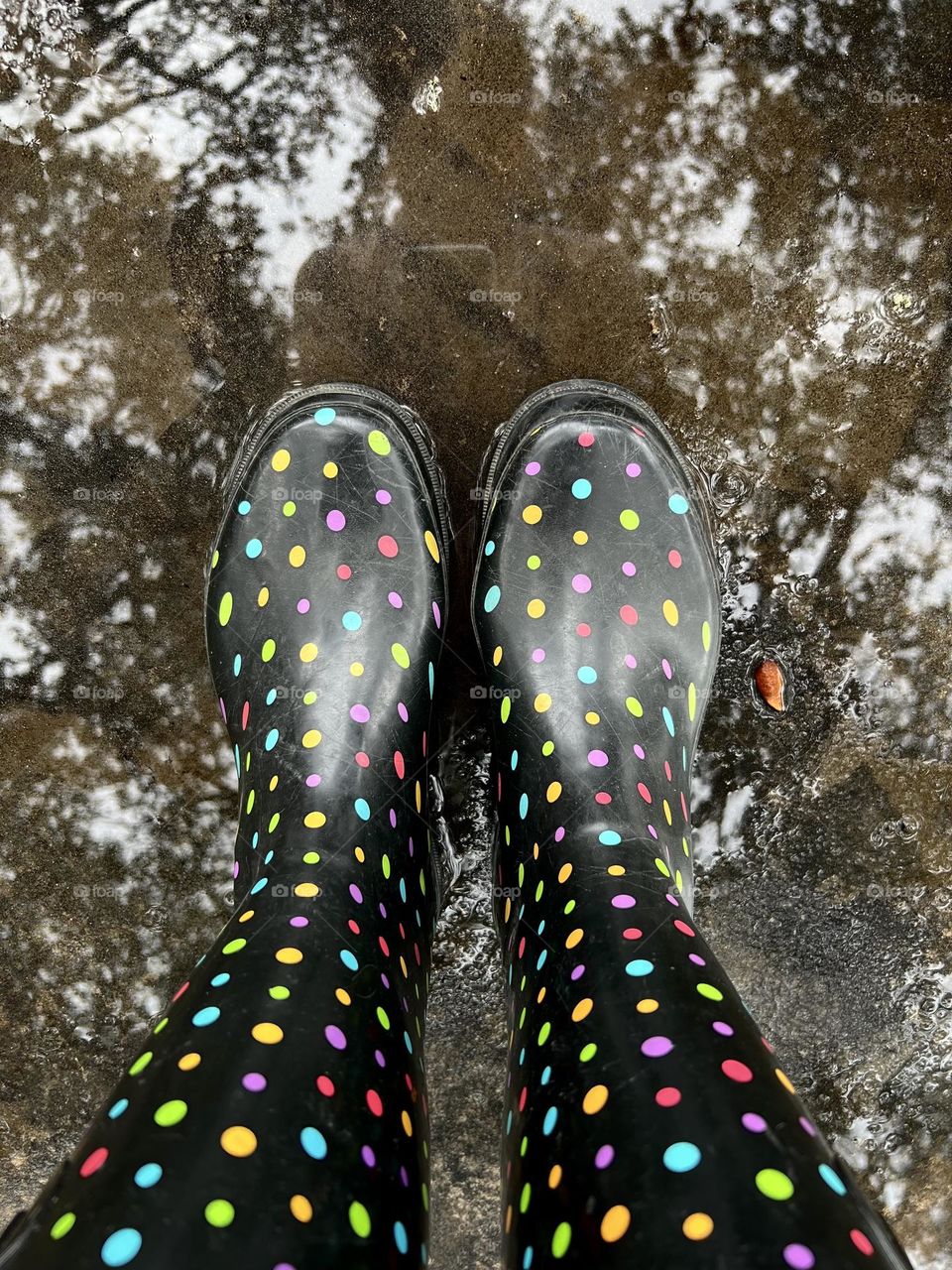 Looking down at my black rain boots with polka dots. Had to stand in the puddle of course!