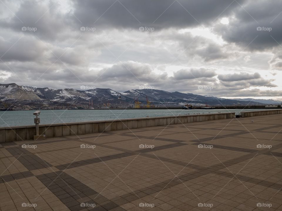 The embankment of the sea. Cloudy weather. Mountain view. Winter.