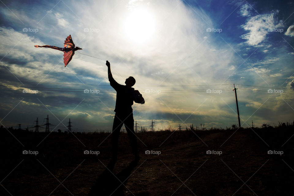 silhouette of a man flying a kite