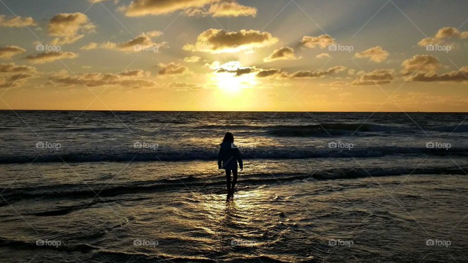 little girl in the sunset by the sea