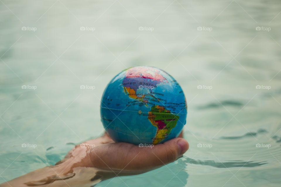 hand holding world sphere, showing North and South America continents