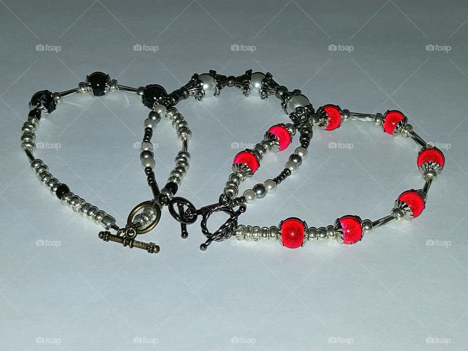 Homemade bracelets in red, silver, black and white.